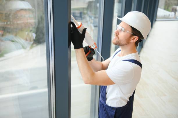 handsome young man installing bay window in new house construction site